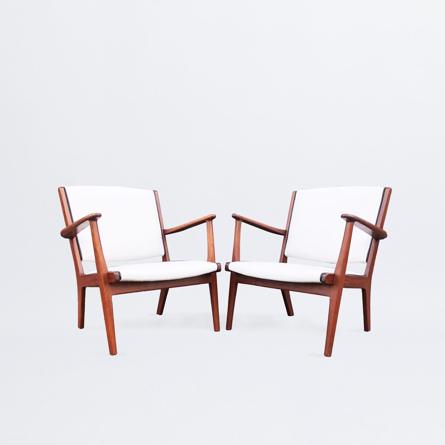 Pair of easy chairs with leather piping